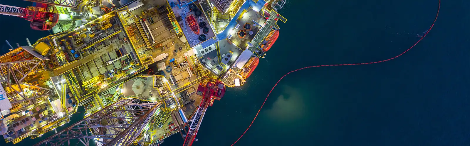 Aerial view of a night scene with a lighted offshore oil rig.