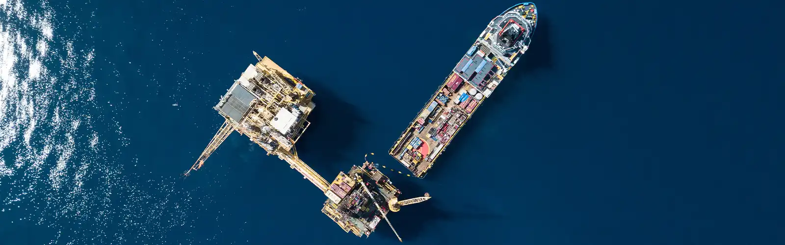Aerial view of a vessel and an offshore oil rig.