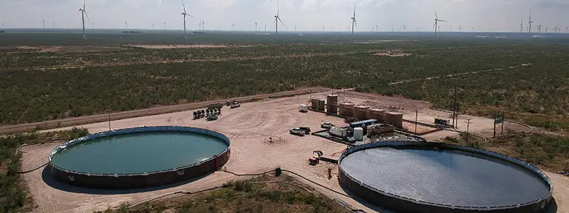 Foto av en anläggning i västra Texas med två stora cirkulära tankar som används för att lagra och återvinna vatten.
