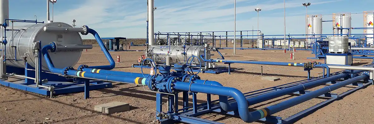 En tidig produktionsanläggning (EPF) i Argentina, med blå rörledningar och silverfärgade tankcontainrar uppställda på en plattform.