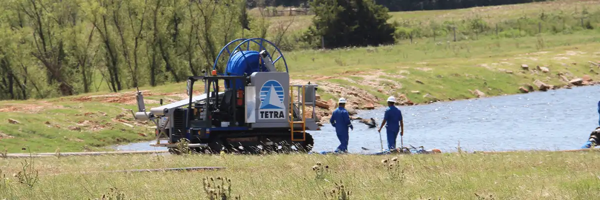 Två TETRA-anställda i overaller och skyddshjälmar som arbetar på plats med projektet Water Sourcing Permian Basin.