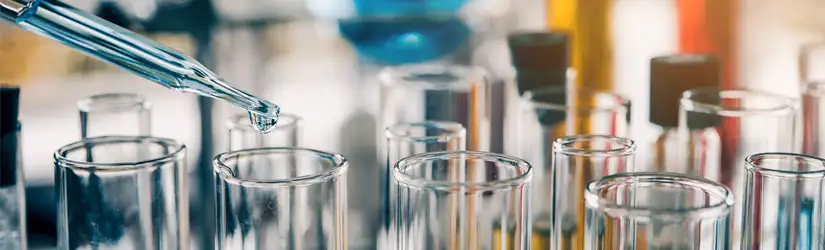 Laboratorium bestående av provrör och en pipett som administrerar en vätska.