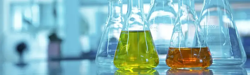 Laboratory flasks glassware, with two containing colored liquids.