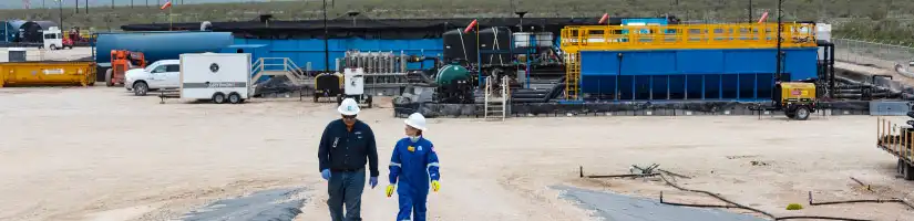 Two TETRA employees with hard hats and work attire, walking through a production facility.