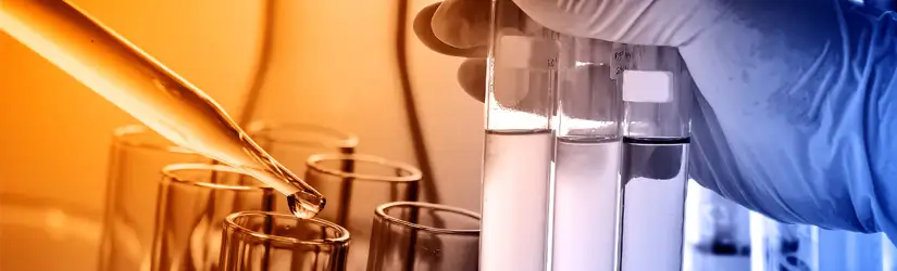 Laboratorieglasvaror, med provrör, pipett, cylinderkärl och en bägare i bakgrunden.